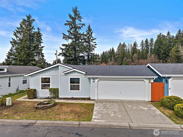 ranch-style home featuring an attached garage, concrete driveway, and a shingled roof