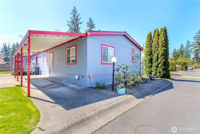 view of home's exterior featuring a carport, concrete driveway, and crawl space