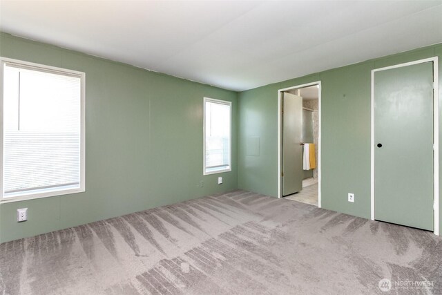 unfurnished bedroom featuring carpet and ensuite bath