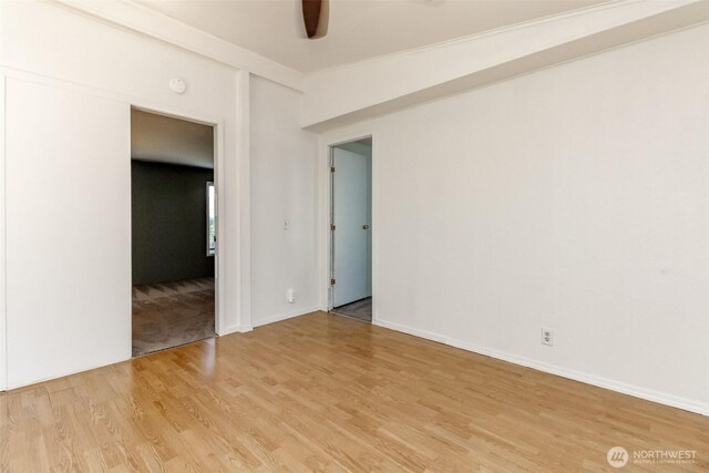 spare room with baseboards, ceiling fan, and light wood-style flooring
