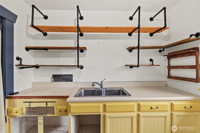 kitchen featuring open shelves, light countertops, and a sink