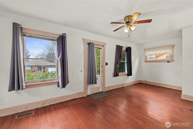 spare room with visible vents, baseboards, a ceiling fan, and wood finished floors