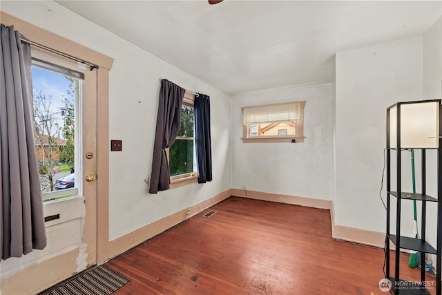 unfurnished room with visible vents, baseboards, and wood finished floors