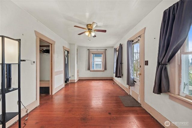 interior space featuring ceiling fan, baseboards, and wood finished floors