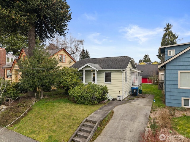 view of front of property with a shingled roof and a front lawn