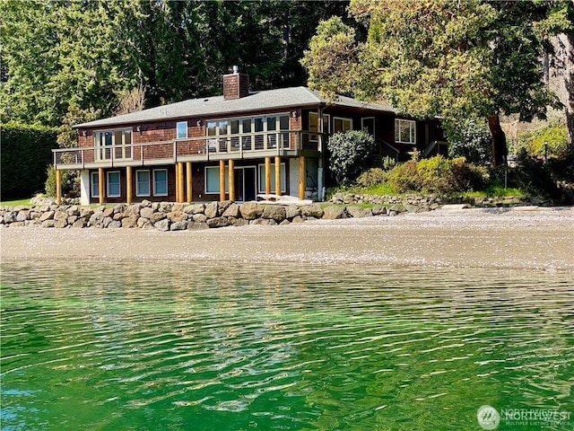 view of front of house featuring a chimney and a water view