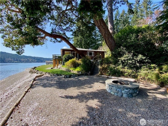 view of front of house featuring a water view, an outdoor fire pit, and stairway