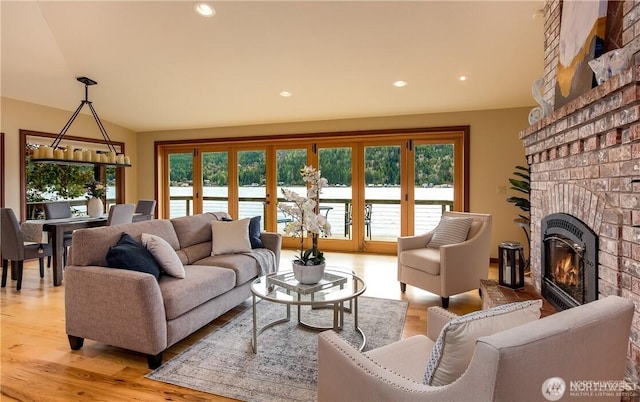 living area with light wood-style floors, recessed lighting, and a fireplace