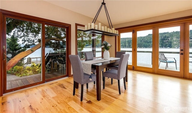 dining room with a view of trees and light wood finished floors