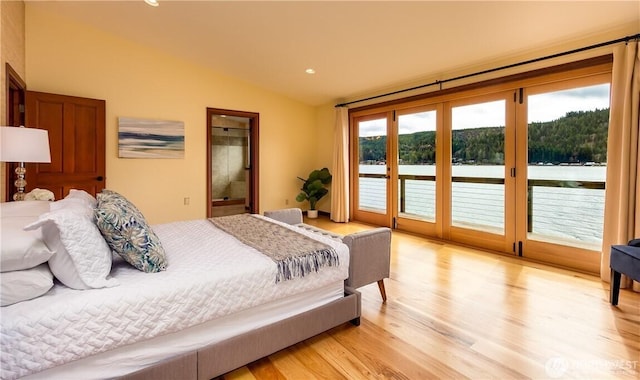 bedroom with lofted ceiling, access to outside, light wood finished floors, and connected bathroom