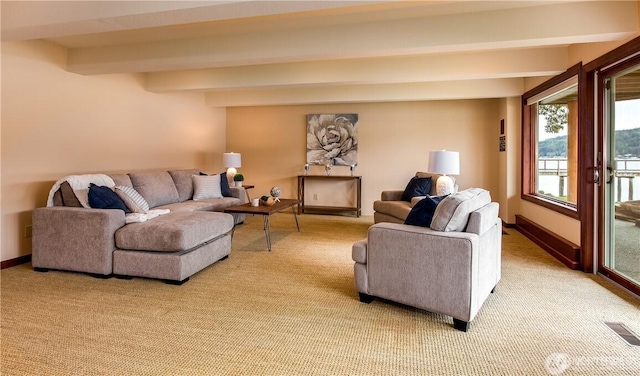 living area with light colored carpet, beam ceiling, visible vents, and baseboards