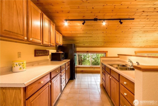 kitchen featuring light tile patterned floors, lofted ceiling, a sink, wood ceiling, and black appliances