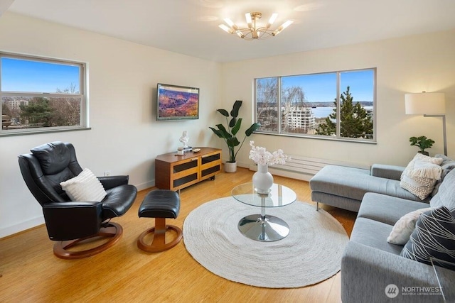 living room featuring baseboards, an inviting chandelier, and wood finished floors