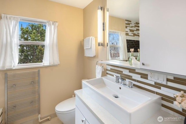 bathroom with toilet, vanity, and radiator heating unit