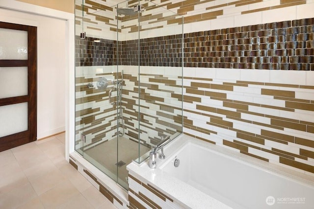 full bathroom featuring a garden tub, a shower stall, and tile patterned flooring