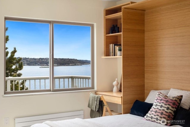 bedroom featuring multiple windows, a water view, and radiator