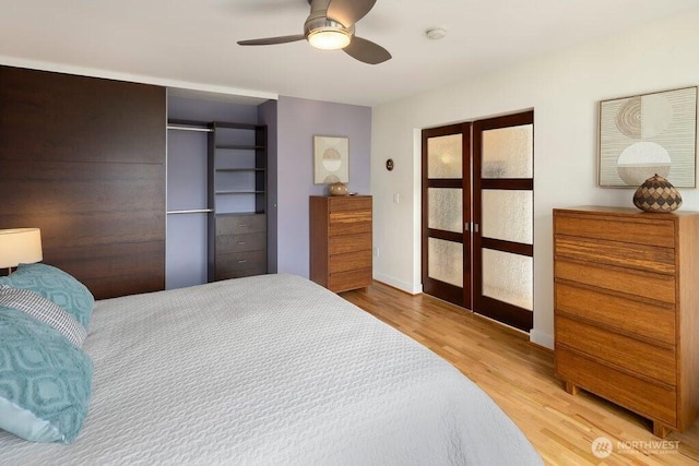 bedroom featuring a ceiling fan, wood finished floors, and french doors