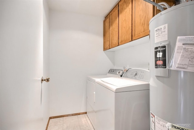 washroom featuring washer and dryer, baseboards, cabinet space, and water heater