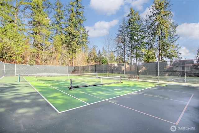 view of tennis court featuring fence