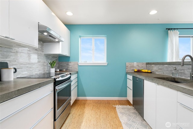 kitchen featuring ventilation hood, dishwashing machine, stainless steel range with electric cooktop, white cabinetry, and a sink