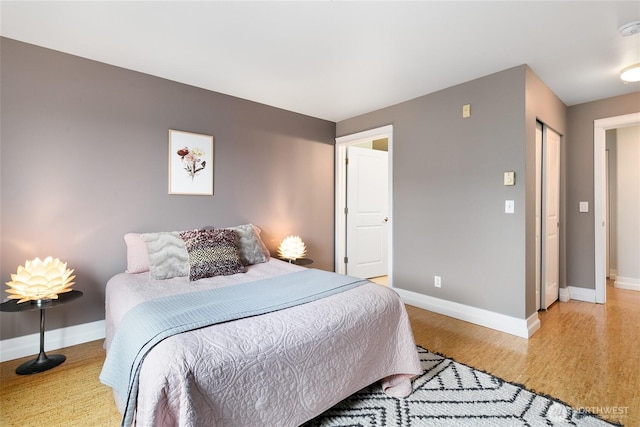 bedroom featuring baseboards and light wood finished floors