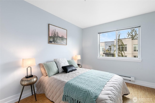 bedroom featuring wood finished floors, baseboards, and a baseboard radiator