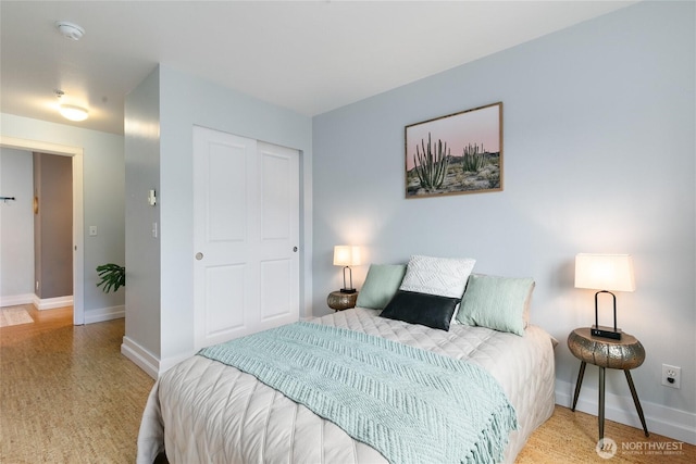 bedroom with a closet, baseboards, and wood finished floors