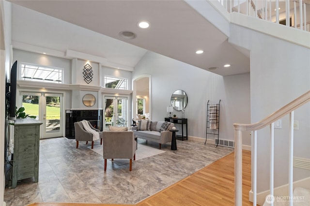 living room with a high ceiling, stairs, and visible vents