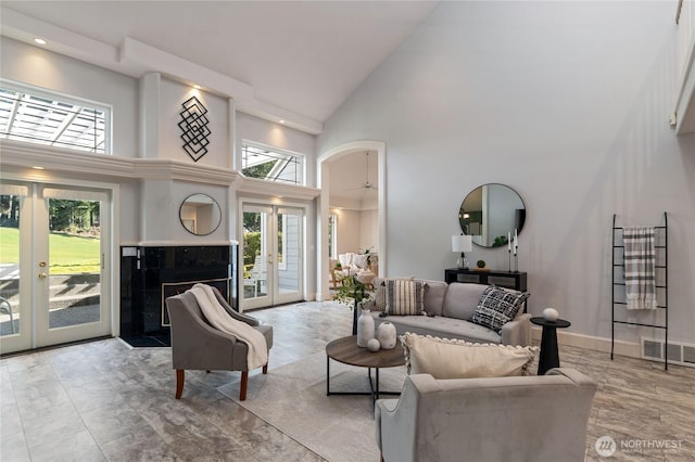 living room featuring visible vents, arched walkways, baseboards, french doors, and high vaulted ceiling