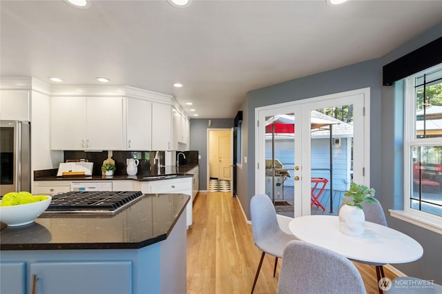 kitchen featuring decorative backsplash, french doors, light wood-type flooring, smart refrigerator, and white cabinetry