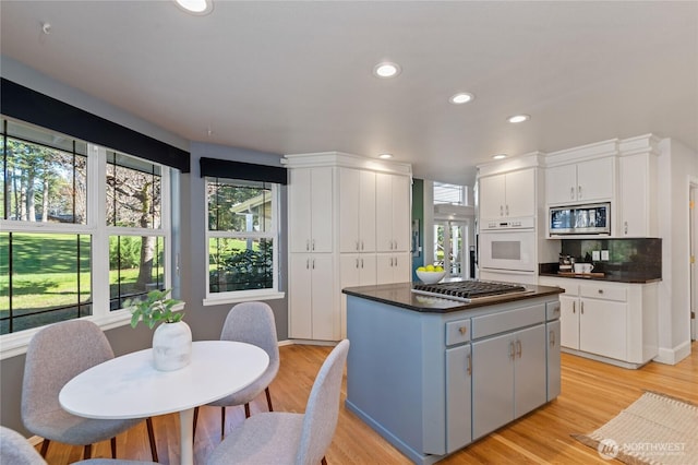 kitchen featuring appliances with stainless steel finishes, dark countertops, a center island, and white cabinetry