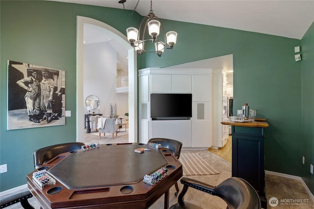 interior space with baseboards, high vaulted ceiling, and an inviting chandelier