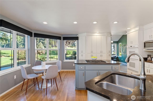 kitchen featuring stainless steel appliances, a center island, a wealth of natural light, and a sink