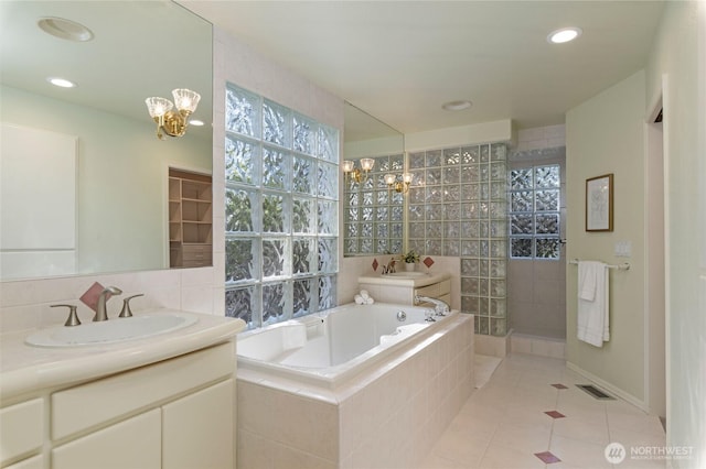 bathroom with a garden tub, an inviting chandelier, vanity, tile patterned flooring, and walk in shower