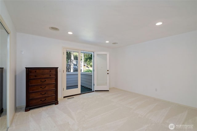 spare room featuring recessed lighting, light colored carpet, and visible vents