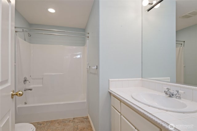 bathroom with visible vents, shower / bath combination, toilet, vanity, and baseboards