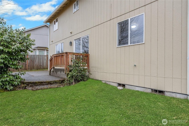 back of house with crawl space, a yard, fence, and a patio