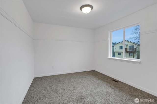 spare room featuring baseboards, visible vents, and carpet flooring