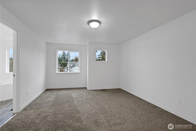 carpeted spare room with baseboards