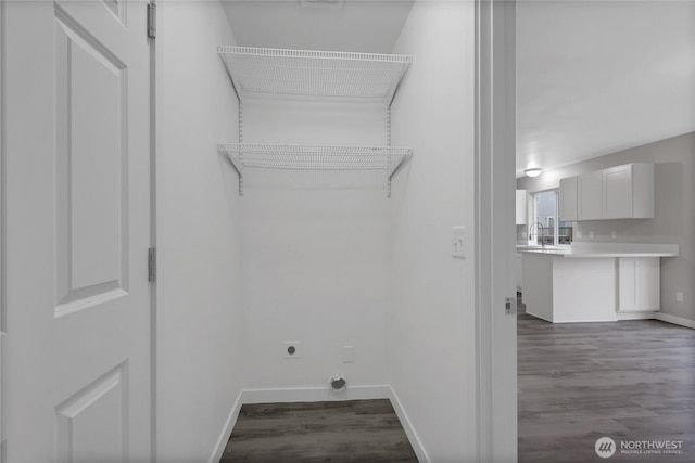 washroom featuring laundry area, dark wood-type flooring, a sink, and electric dryer hookup