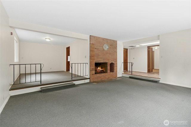 unfurnished living room with carpet, a brick fireplace, and baseboards