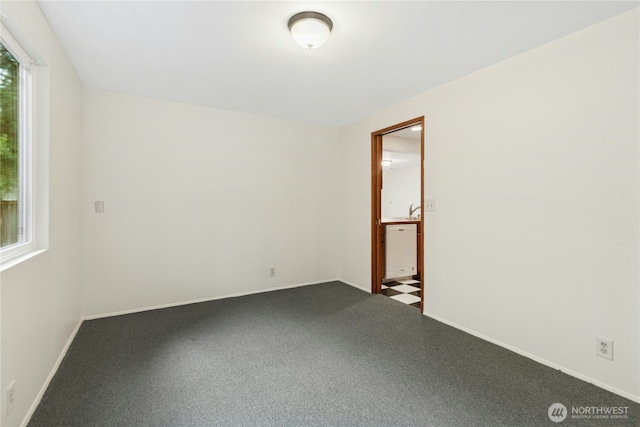 empty room with carpet and baseboards