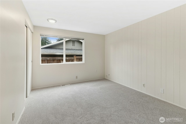 spare room featuring carpet floors and visible vents