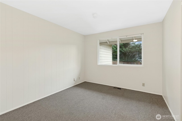 carpeted empty room with visible vents and baseboards