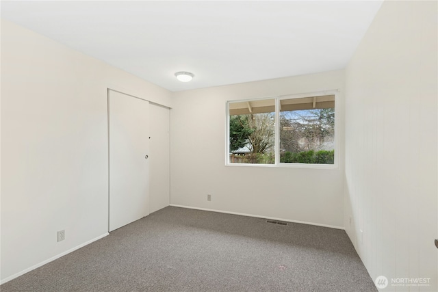 spare room featuring carpet flooring and baseboards