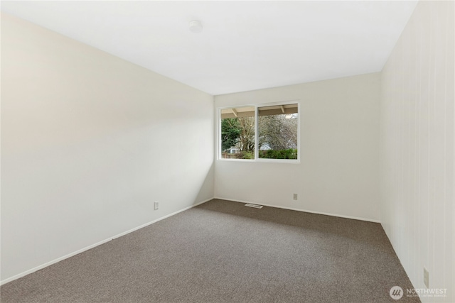 spare room with carpet floors, baseboards, and visible vents