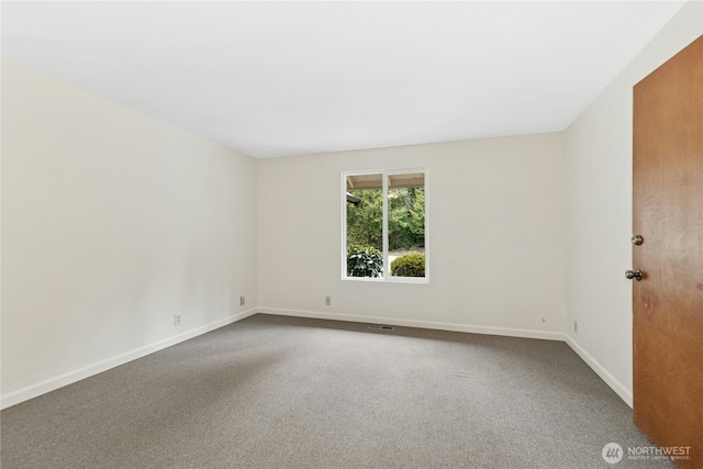 carpeted spare room with visible vents and baseboards