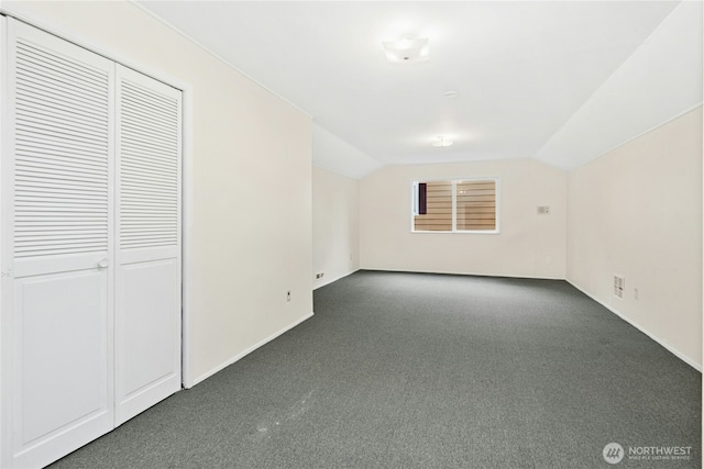 additional living space with carpet floors, visible vents, vaulted ceiling, and baseboards