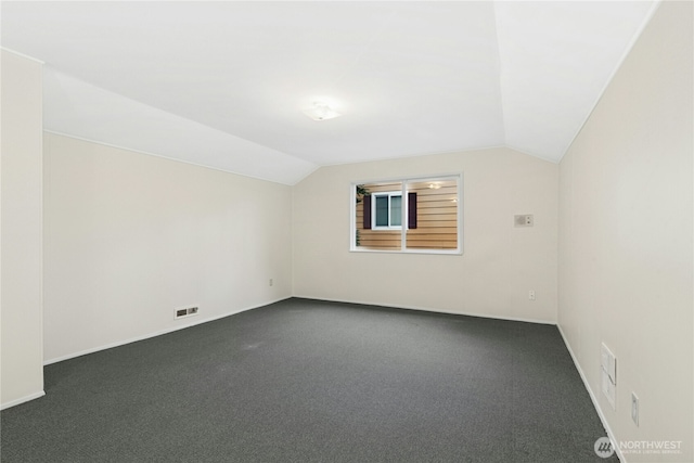 additional living space featuring lofted ceiling, dark carpet, and visible vents