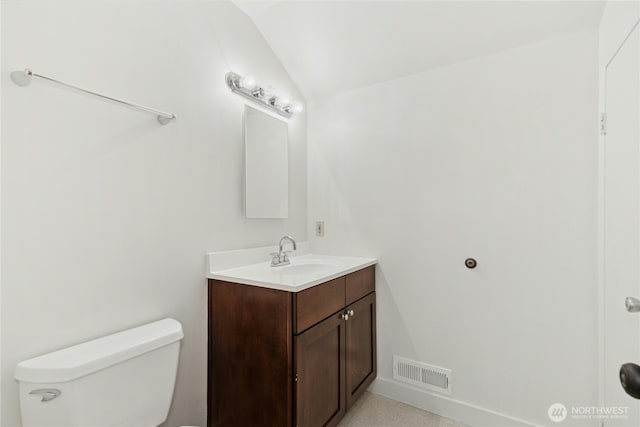 half bath with visible vents, vaulted ceiling, vanity, and toilet